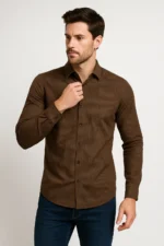 Man adjusting the collar of a slim fit brown full-sleeve shirt with fine vertical stripes, paired with blue jeans.