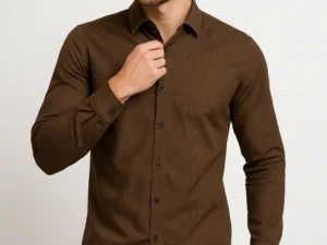 Man adjusting the collar of a slim fit brown full-sleeve shirt with fine vertical stripes, paired with blue jeans.
