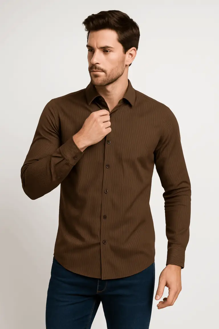 Man adjusting the collar of a slim fit brown full-sleeve shirt with fine vertical stripes, paired with blue jeans.